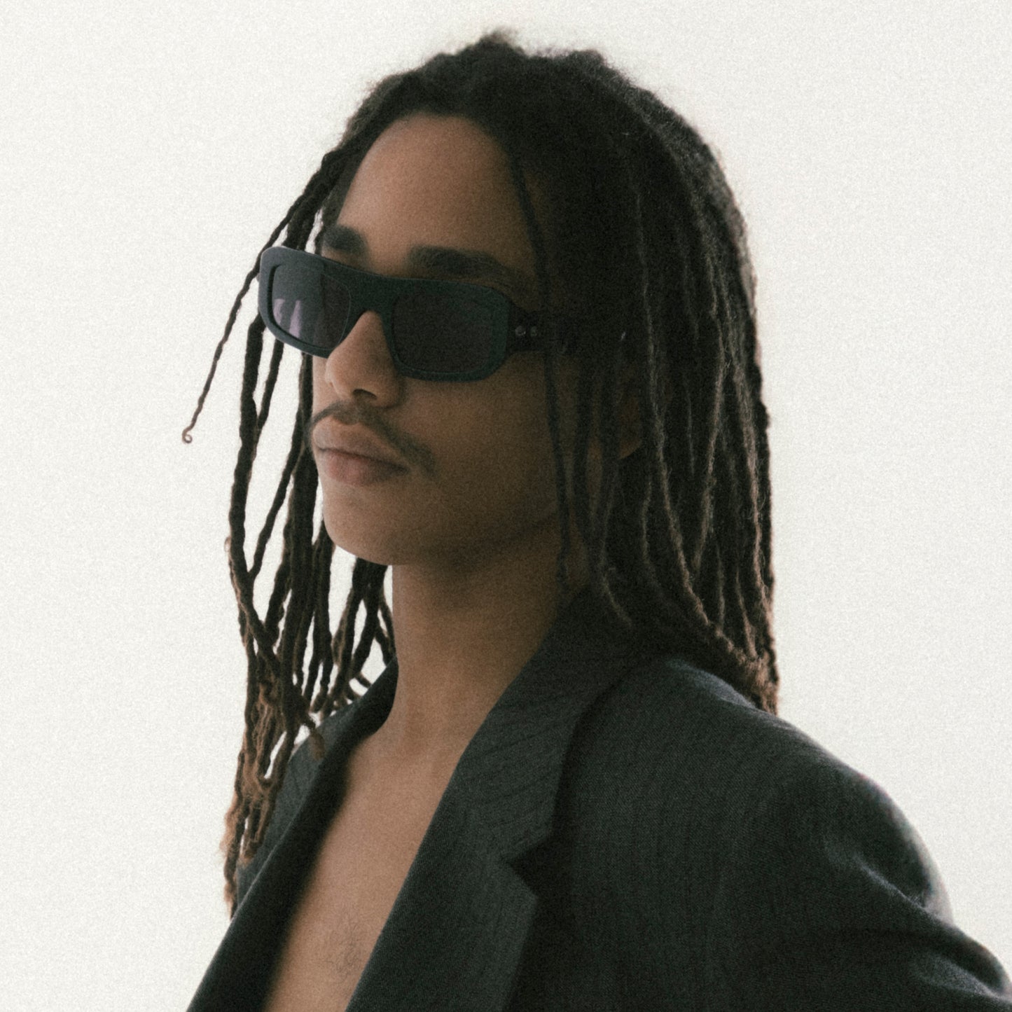 Black rectangular acetate sunglasses worn by male model side view studio image