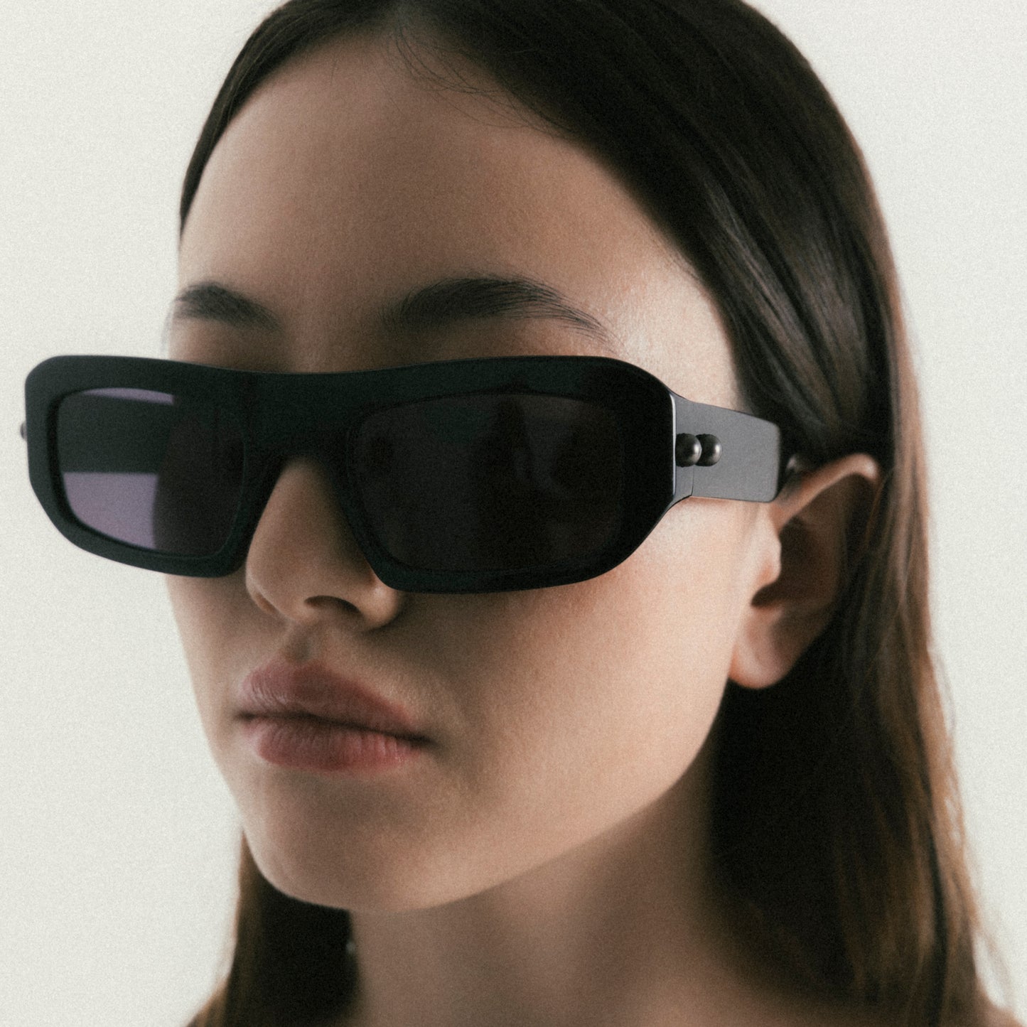 Black rectangular acetate sunglasses worn by female model – side view lifestyle portrait
