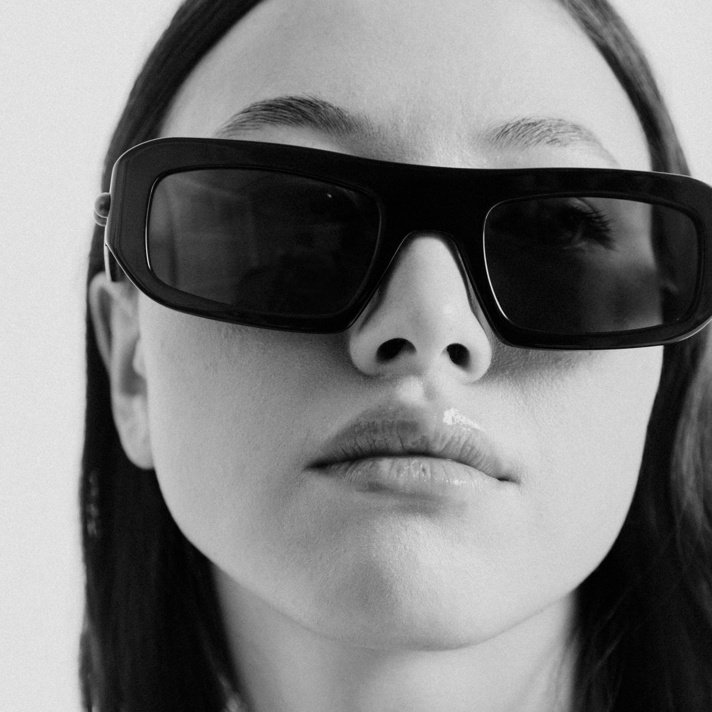 Black rectangular acetate sunglasses worn by female model – front view lifestyle portrait in Black White