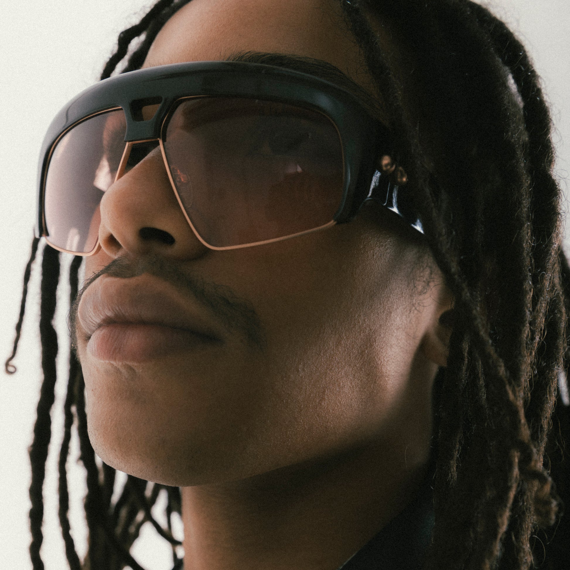 Deep brown oversized aviator sunglasses with acetate and metal frame – male model close-up side view