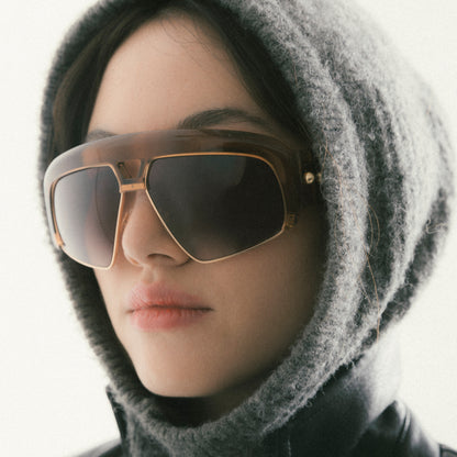 Transparent brown oversized aviator sunglasses with acetate and metal frame – female model view from a soft side angle