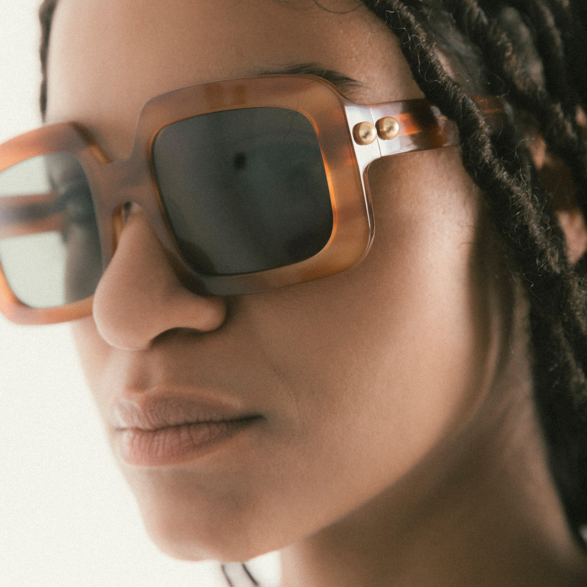 Square brown / striped Havana acetate sunglasses worn by female model – portrait shot slightly angled