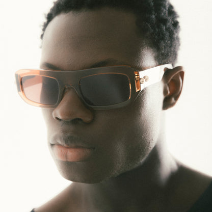 Transparent brown rectangular acetate sunglasses worn by male model side view studio image