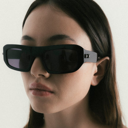 Black rectangular acetate sunglasses worn by female model – side view lifestyle portrait