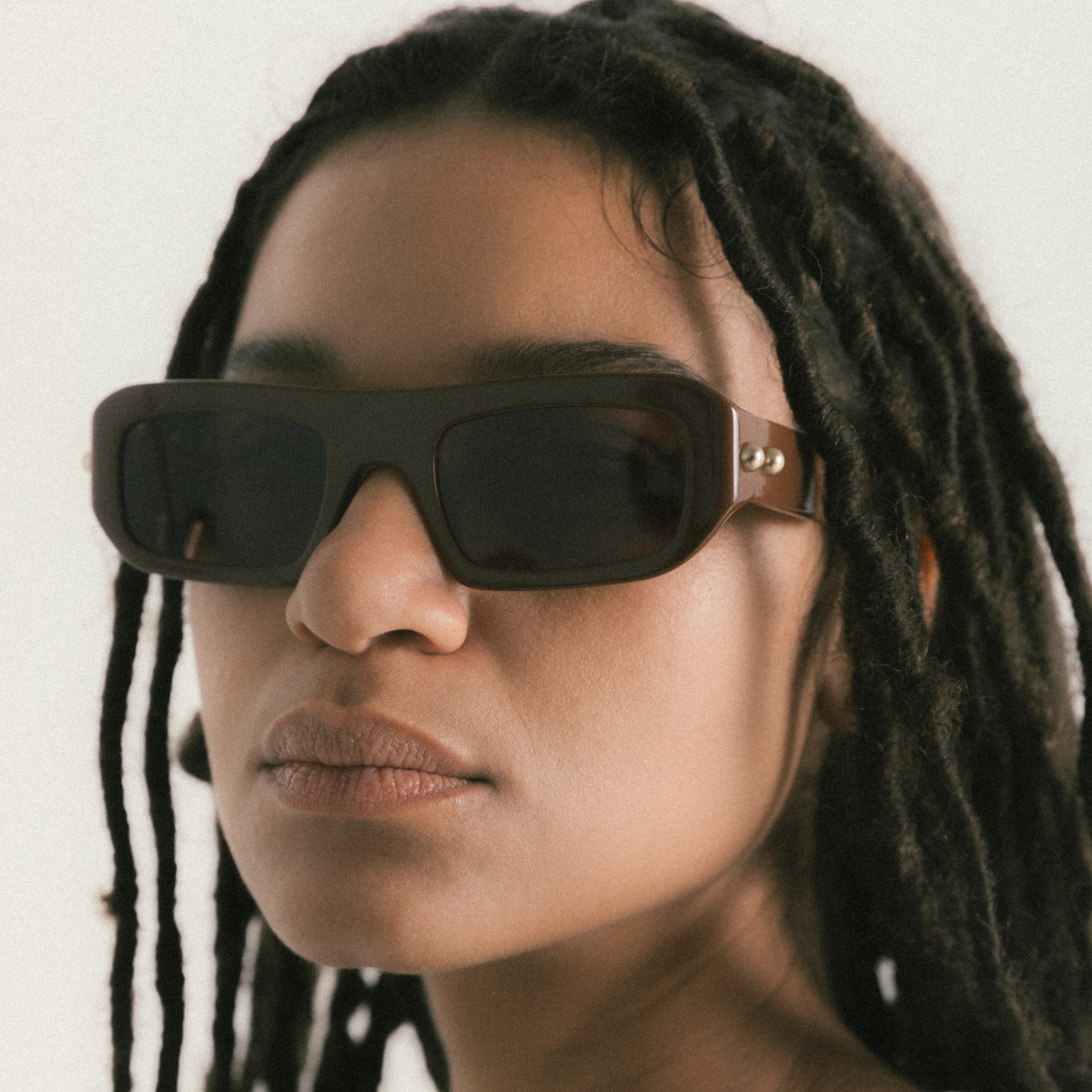 Brown rectangular acetate sunglasses worn by female model – side view lifestyle portrait