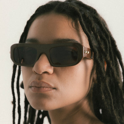 Brown rectangular acetate sunglasses worn by female model – side view lifestyle portrait