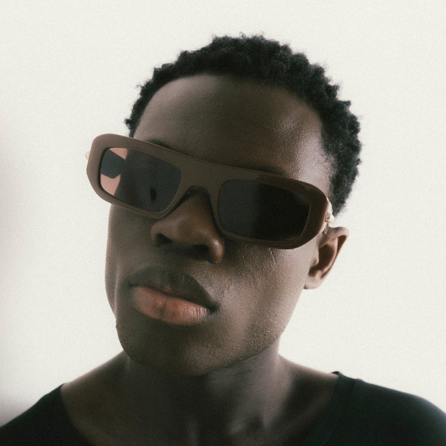 Brown rectangular acetate sunglasses worn by male model – front-facing portrait on neutral background