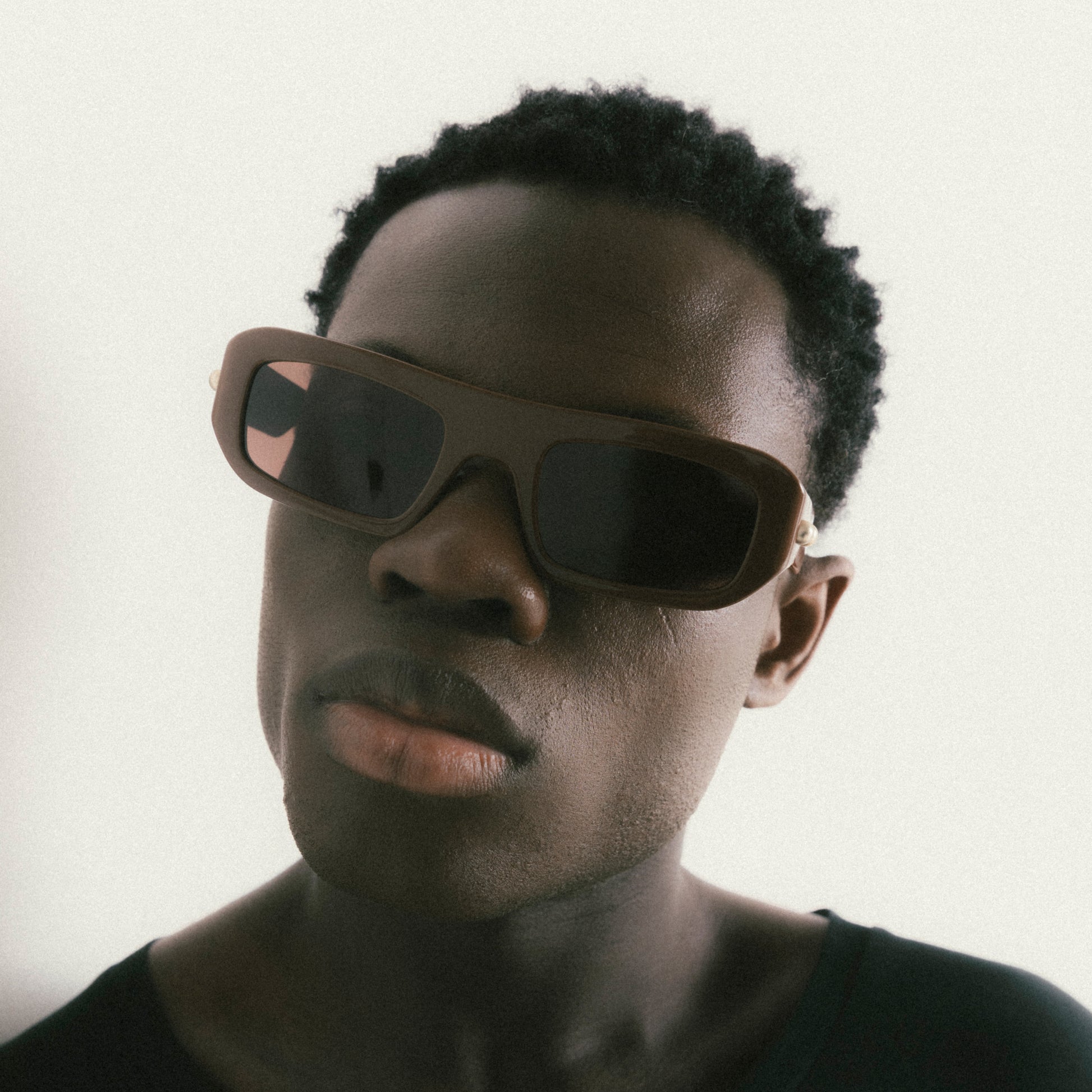 Brown rectangular acetate sunglasses worn by male model – front-facing portrait on neutral background